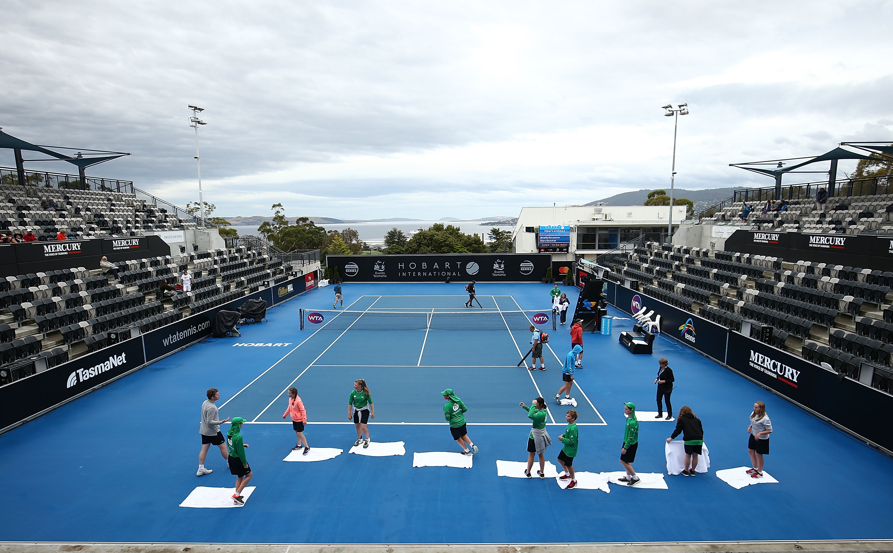 RAINY START: It was all hands on deck to dry the courts after a rain delay affected the start of semifinal day; Getty Images